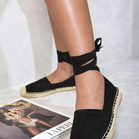 Black espadrilles with ankle ties and woven jute toe caps, side view