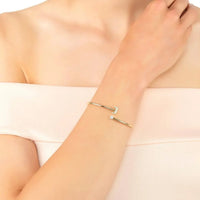 Gold-tone J initial bangle bracelet worn on wrist