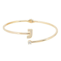 Gold bangle bracelet with J-shaped pavé accent and clear stone detail