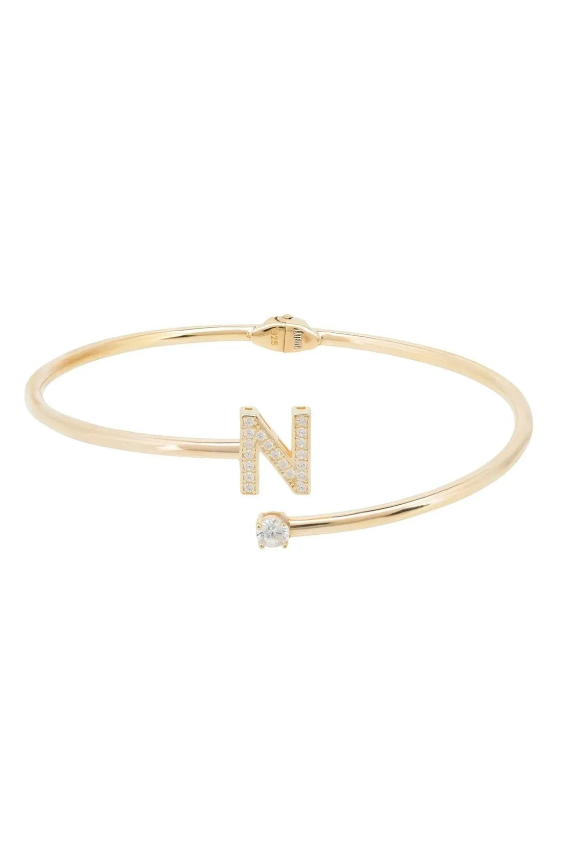 Gold tone hinged bangle with N initial and crystal accents in openwork design
