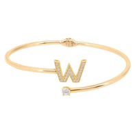 Gold initial W bangle with bezel-set W detail and round crystal centerpiece