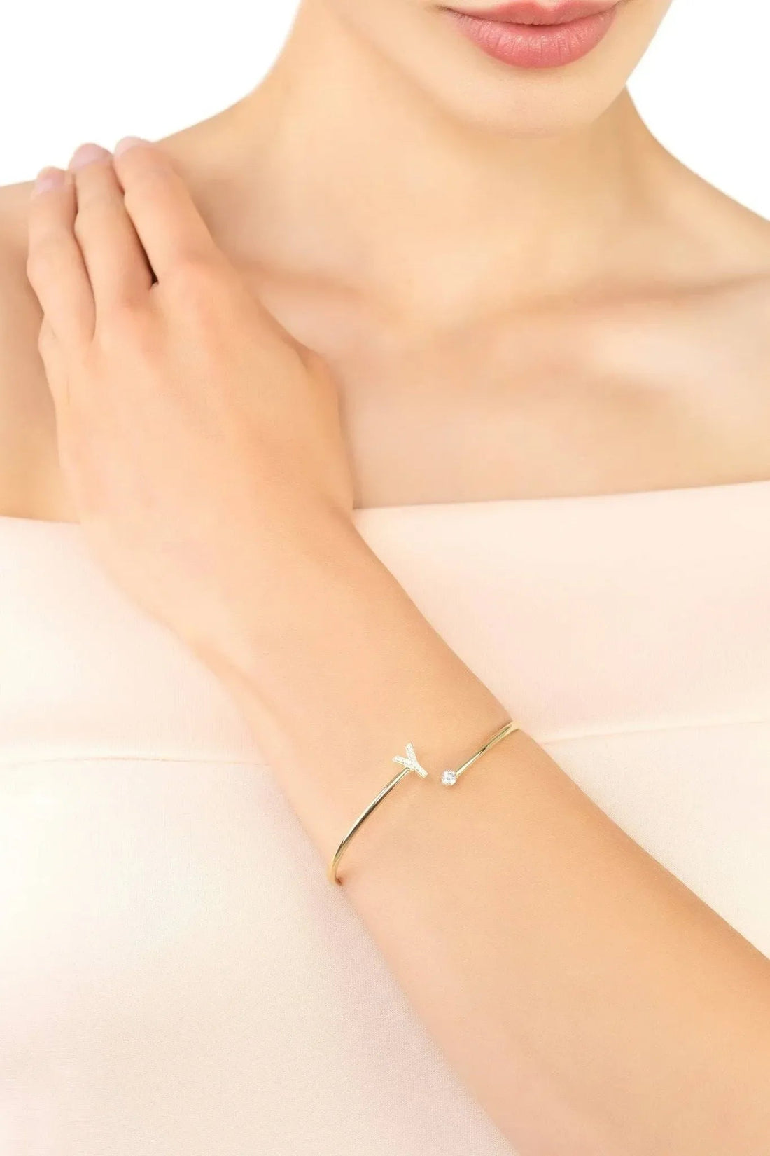 Gold-tone initial Y bangle on wrist with small crystal stones