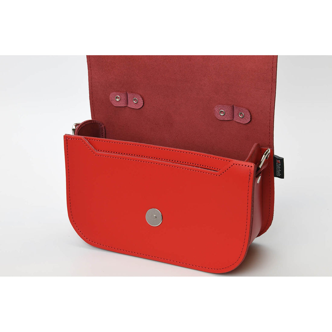 Red leather bag with open flap and snap closure, front pocket visible