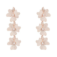 Rose gold triple-drop flower earrings with three textured blossoms.