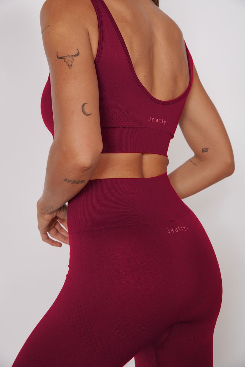 Back view: magenta seamless petite sports bra with racerback straps