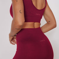 Back view: magenta seamless petite sports bra with racerback straps