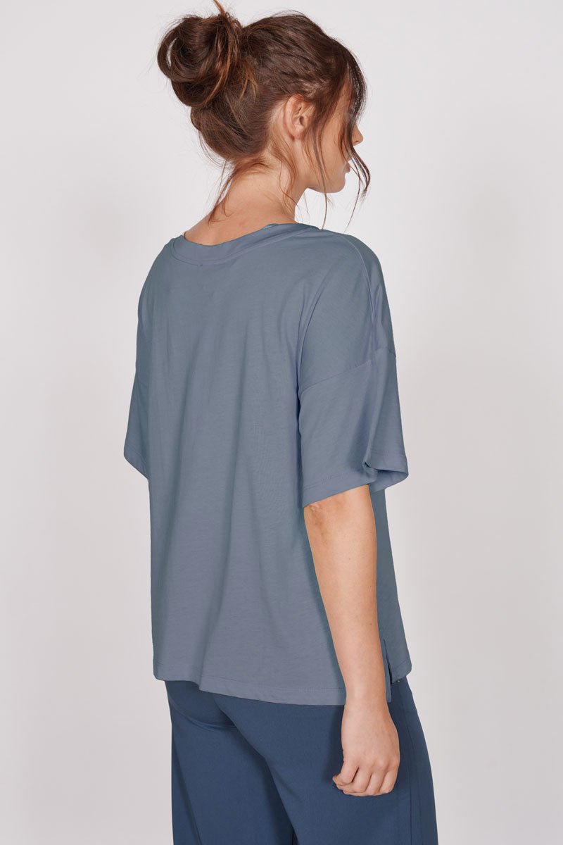 Oversized blue v-neck t-shirt, back view with short sleeves and draped hem