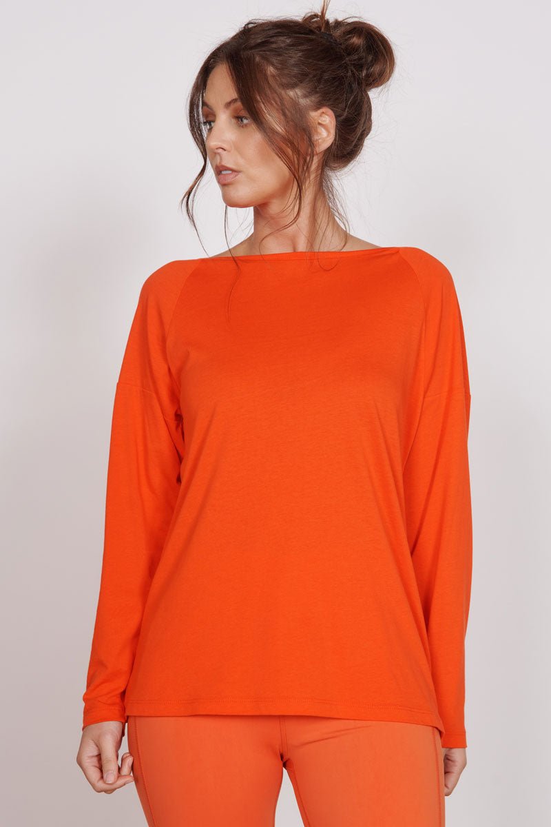 Orange long-sleeve training top with crew neck, smooth lightweight fabric