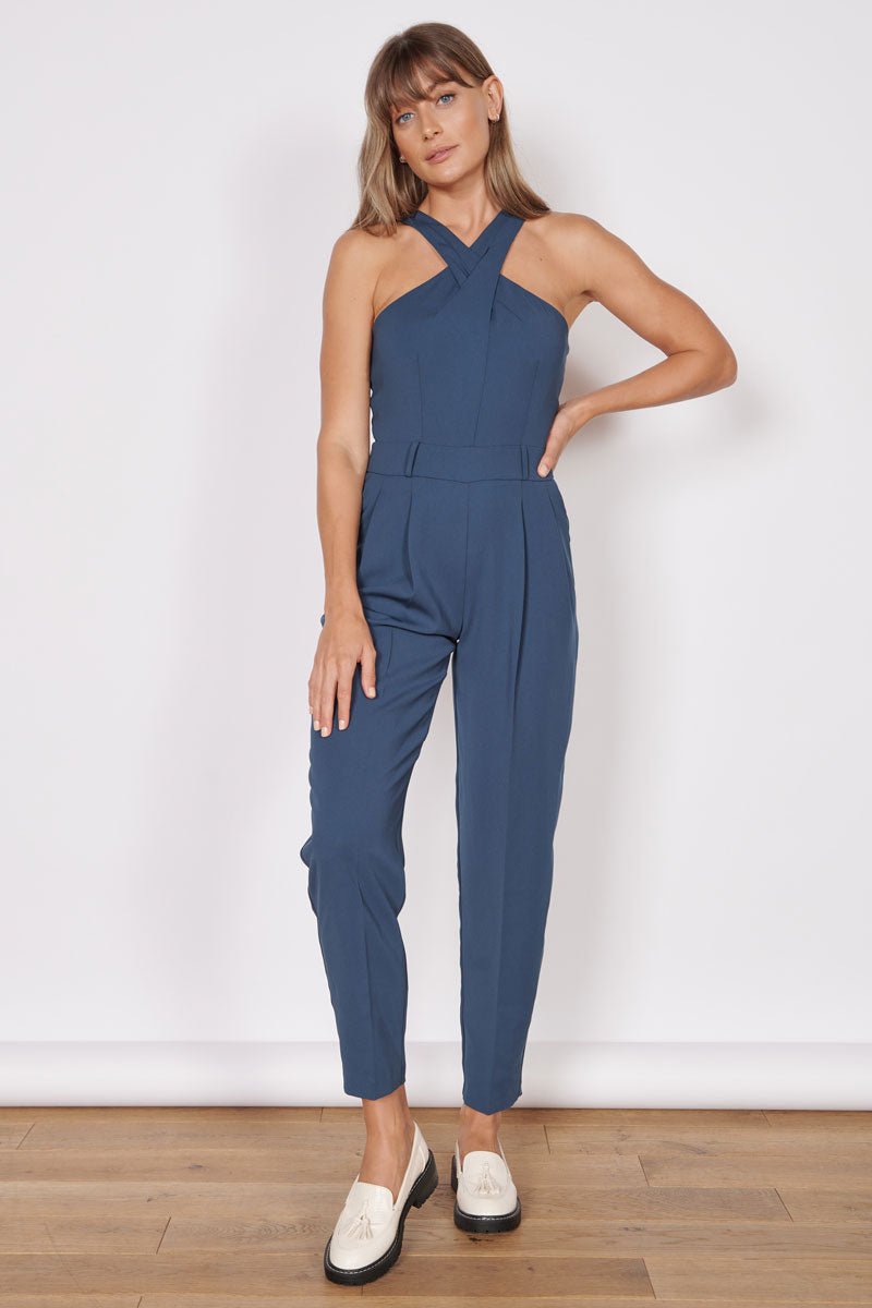 Navy tailored sleeveless jumpsuit with high cross halter neck and front pockets