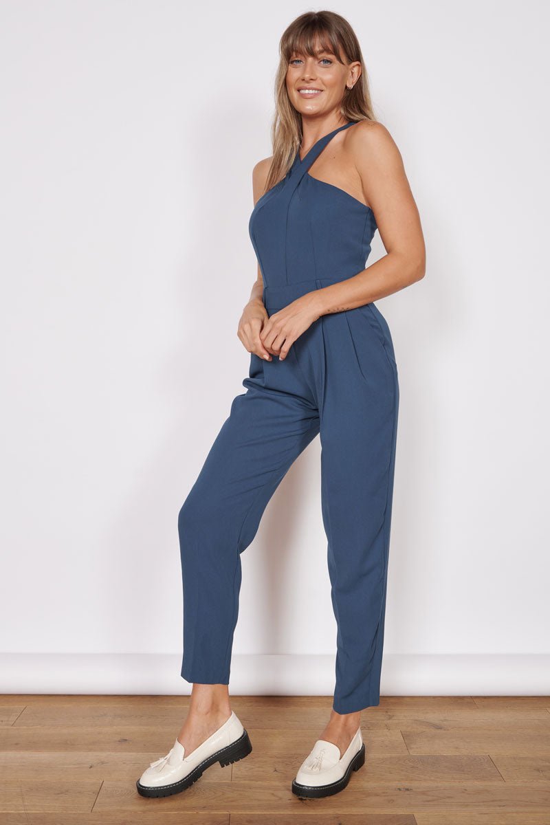 Navy tailored sleeveless jumpsuit with high cross halter neck and tapered legs