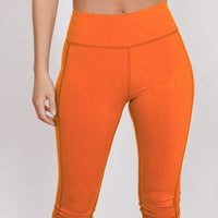 Orange 3/4 sports leggings with hidden zip pocket and contoured waistband