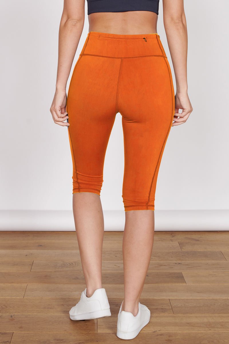 Orange 3/4 sports leggings with hidden zip pocket, front seam and cuffed hem