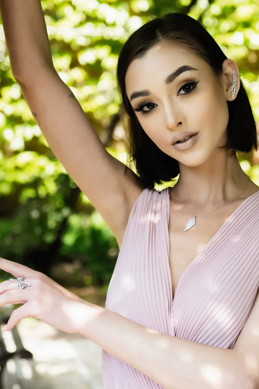 Silver angel wing pendant necklace worn on a model’s neckline with delicate chain