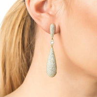 Silver rhinestone teardrop drop earrings worn on ear with dangling oval pieces