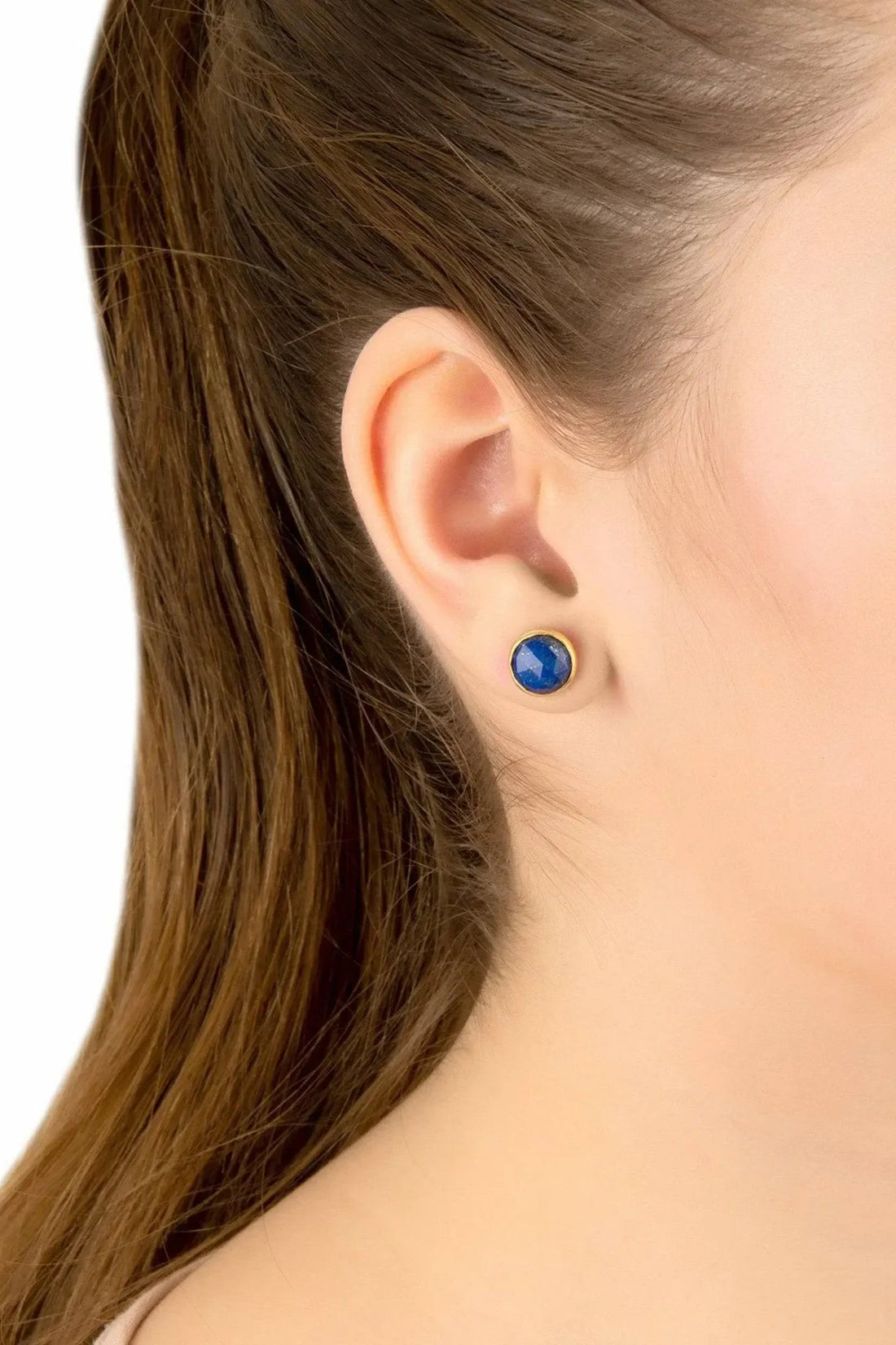 Gold lapis lazuli round stud earrings on ear, blue gemstone disc