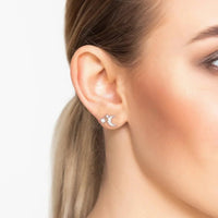 Silver mini moon stud earrings with starburst accents, worn on ear