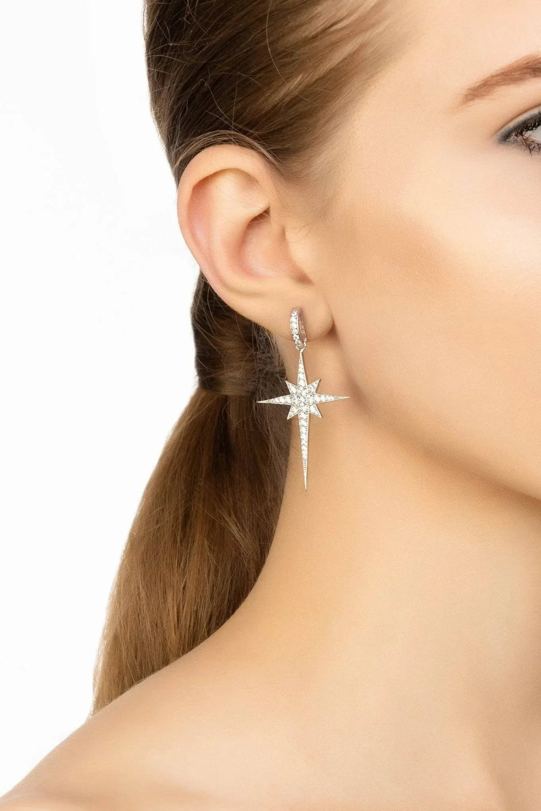 Silver star drop dangle earring on ear with hook back