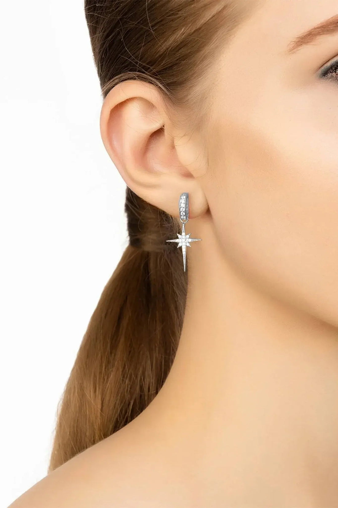 Silver starburst drop earring on model&