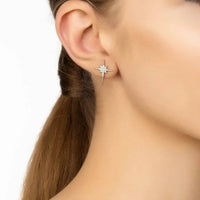 Silver star stud earrings on ear, small sparkling star with drop detail