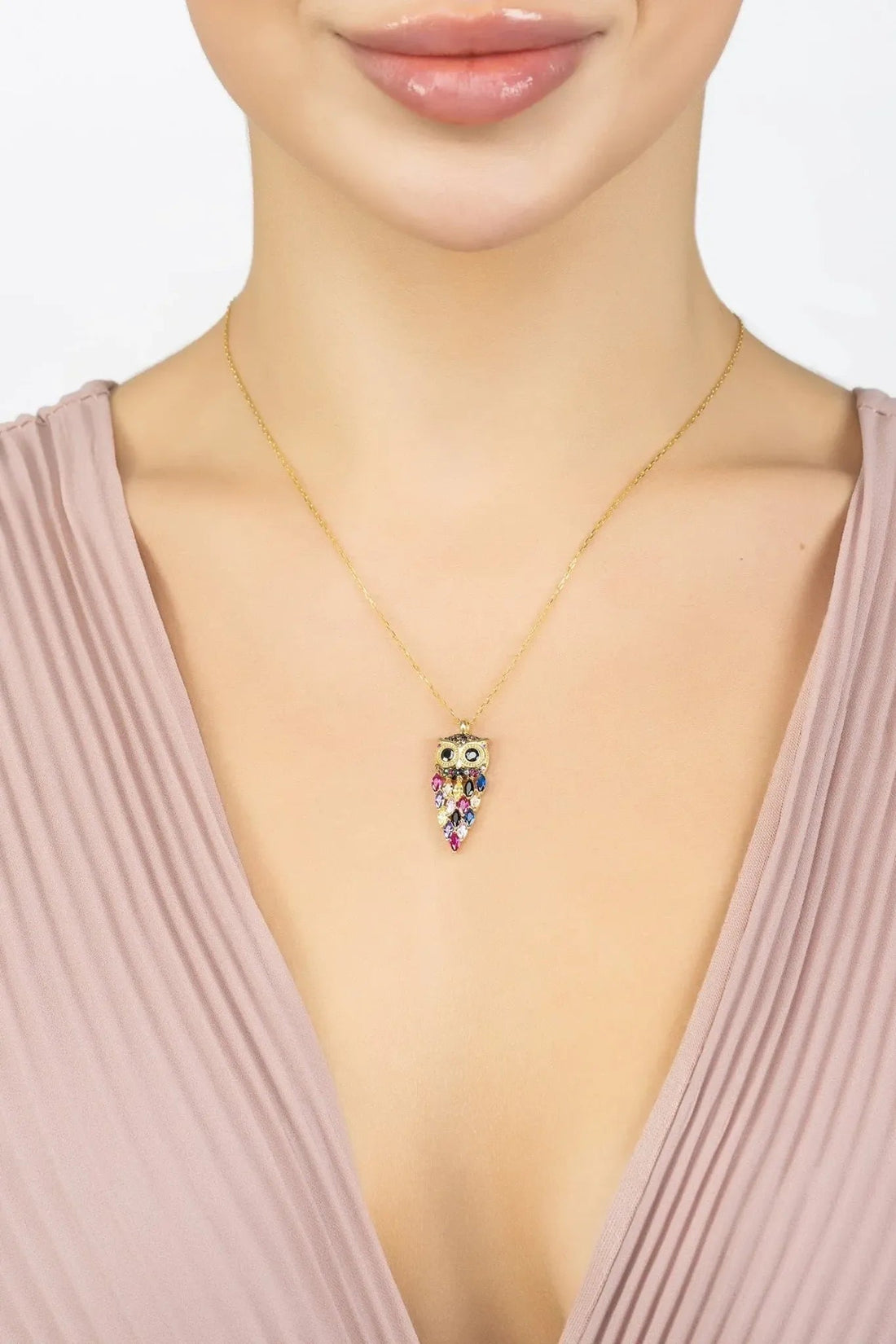 Owl rainbow pendant necklace in gold, worn with a pink dress