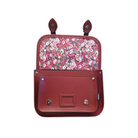 Oxblood leather satchel with floral fabric lining and top clasp, front view