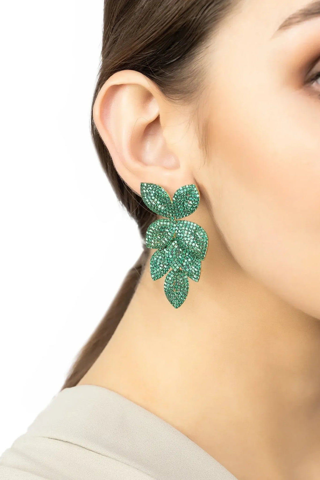 Emerald green rhinestone flower drop earrings on gold hooks, side view