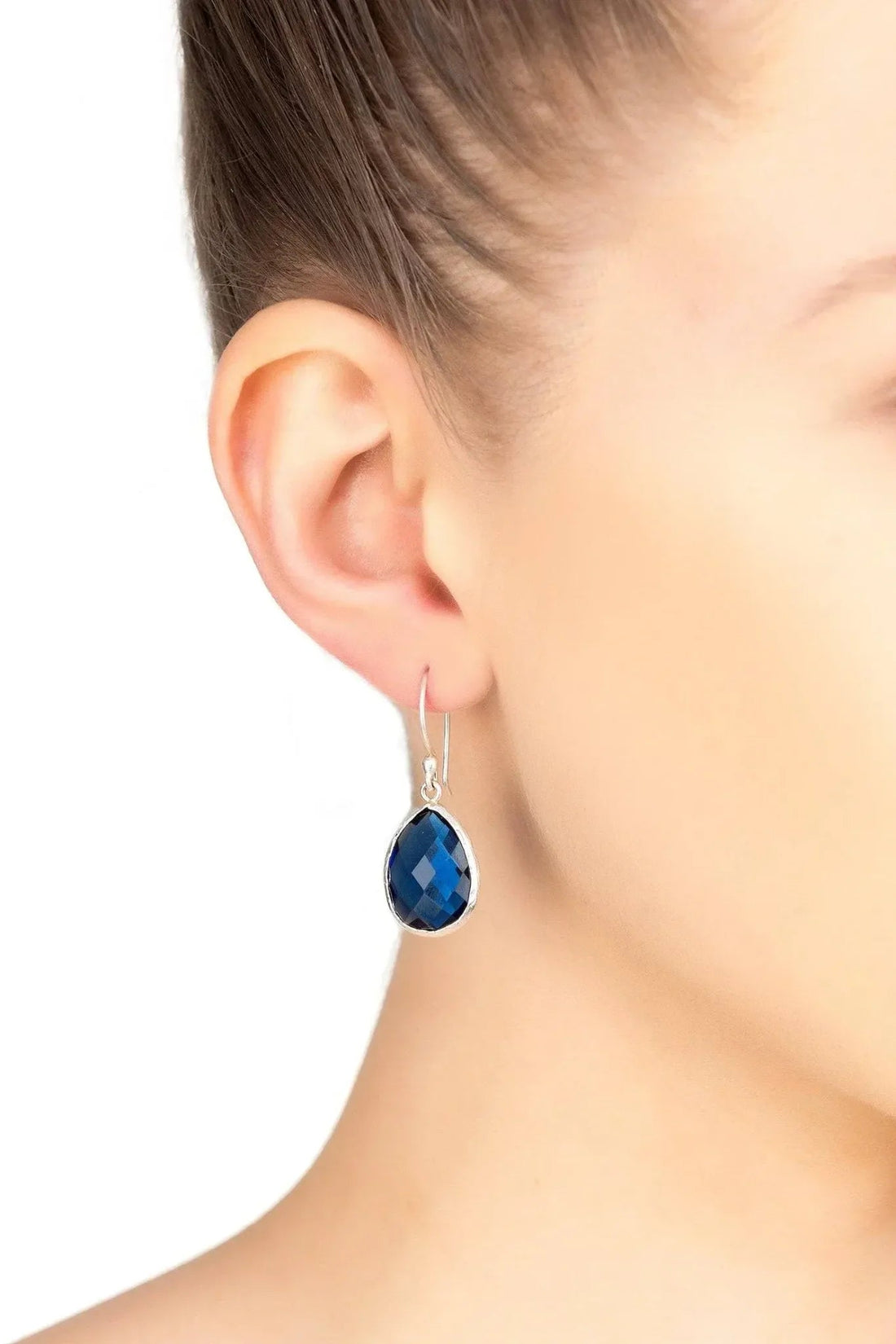 Petite drop earrings with blue faceted teardrop stone and silver hook on ear