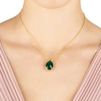 Gold chain necklace with green teardrop onyx pendant at the neckline