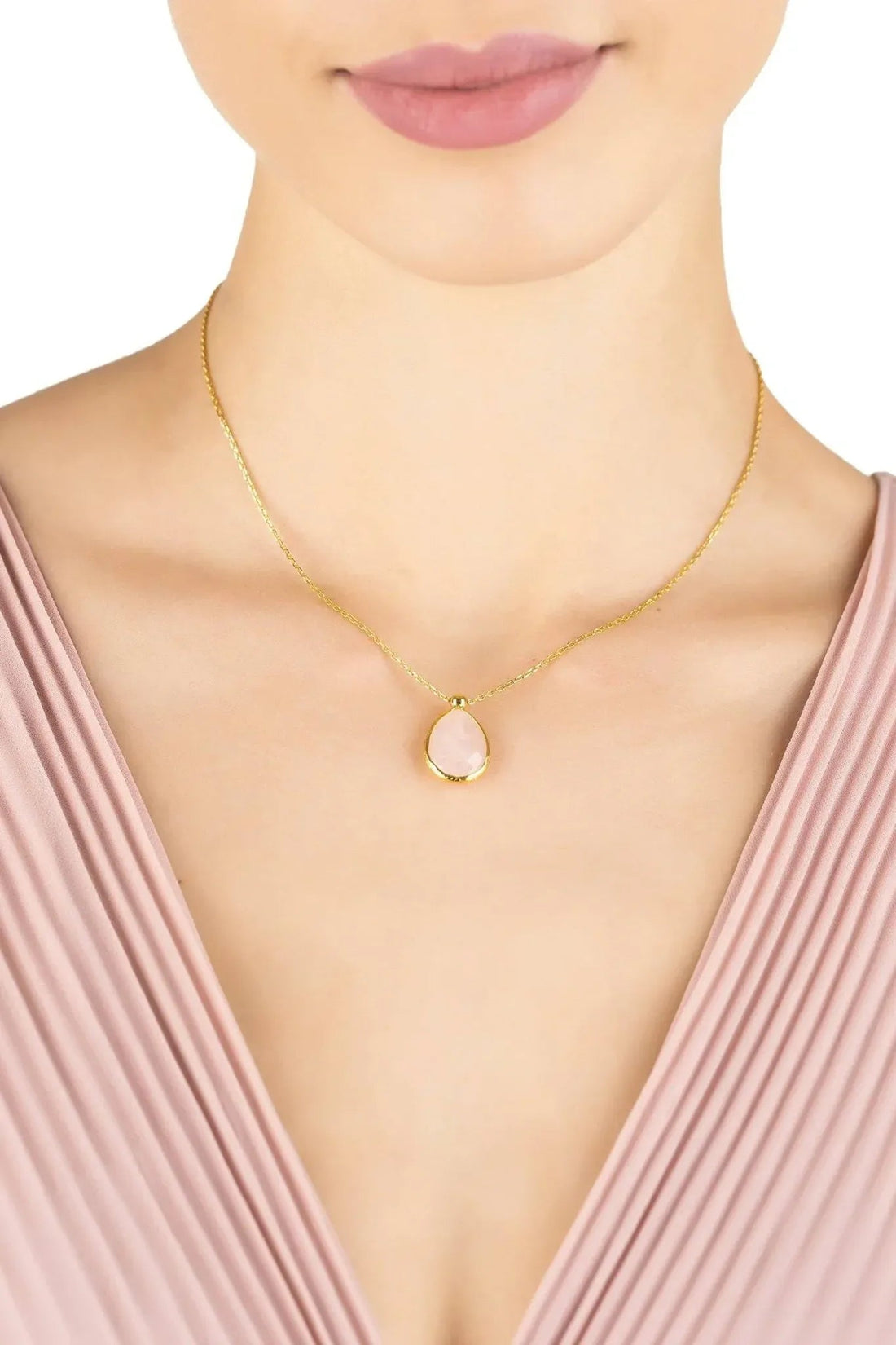 Gold-tone chain necklace with oval rose quartz drop pendant, worn
