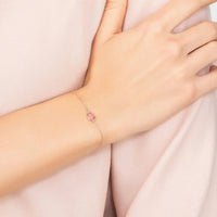 Rose-gold teardrop bracelet with pink gemstone on wrist