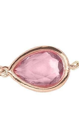 Close-up rose-gold teardrop bracelet with pink gemstone bezel