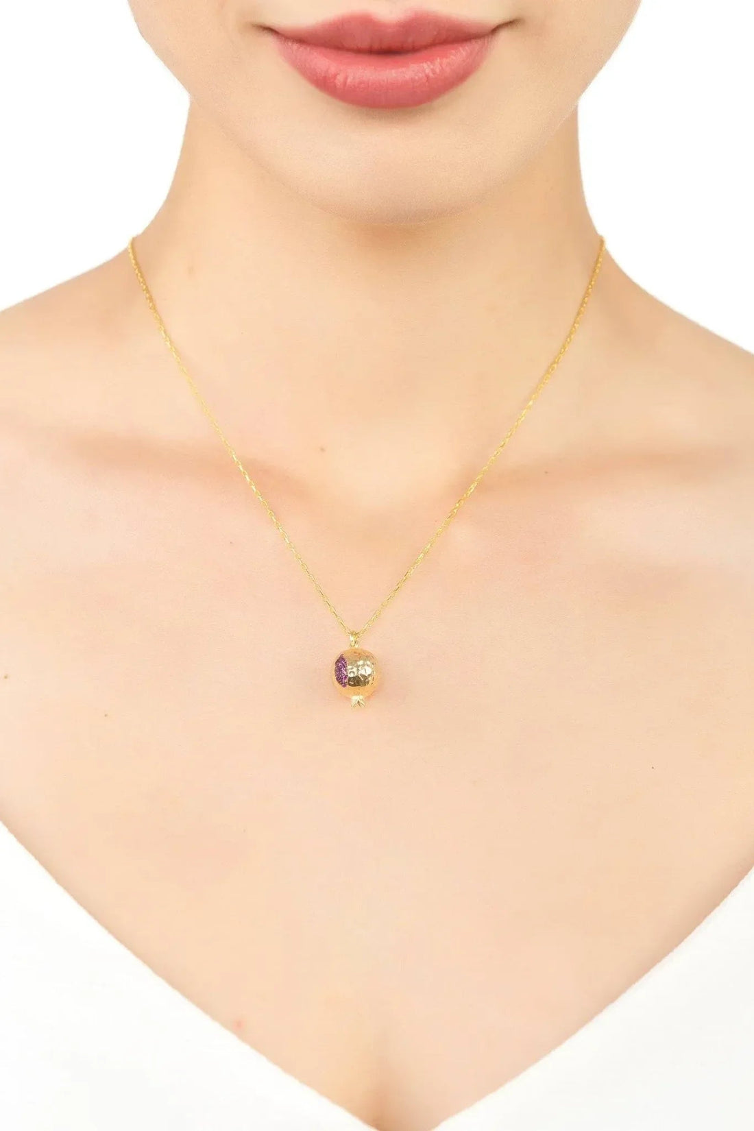 Gold-tone pomegranate charm necklace with purple enamel pendant on neckline
