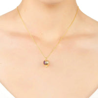 Gold-tone pomegranate charm necklace with purple enamel pendant on neckline