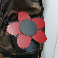Black leather barrel bag with red daisy applique, open top showing camouflage lining
