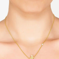 Gold-tone bee pendant necklace on model's neckline with dainty chain