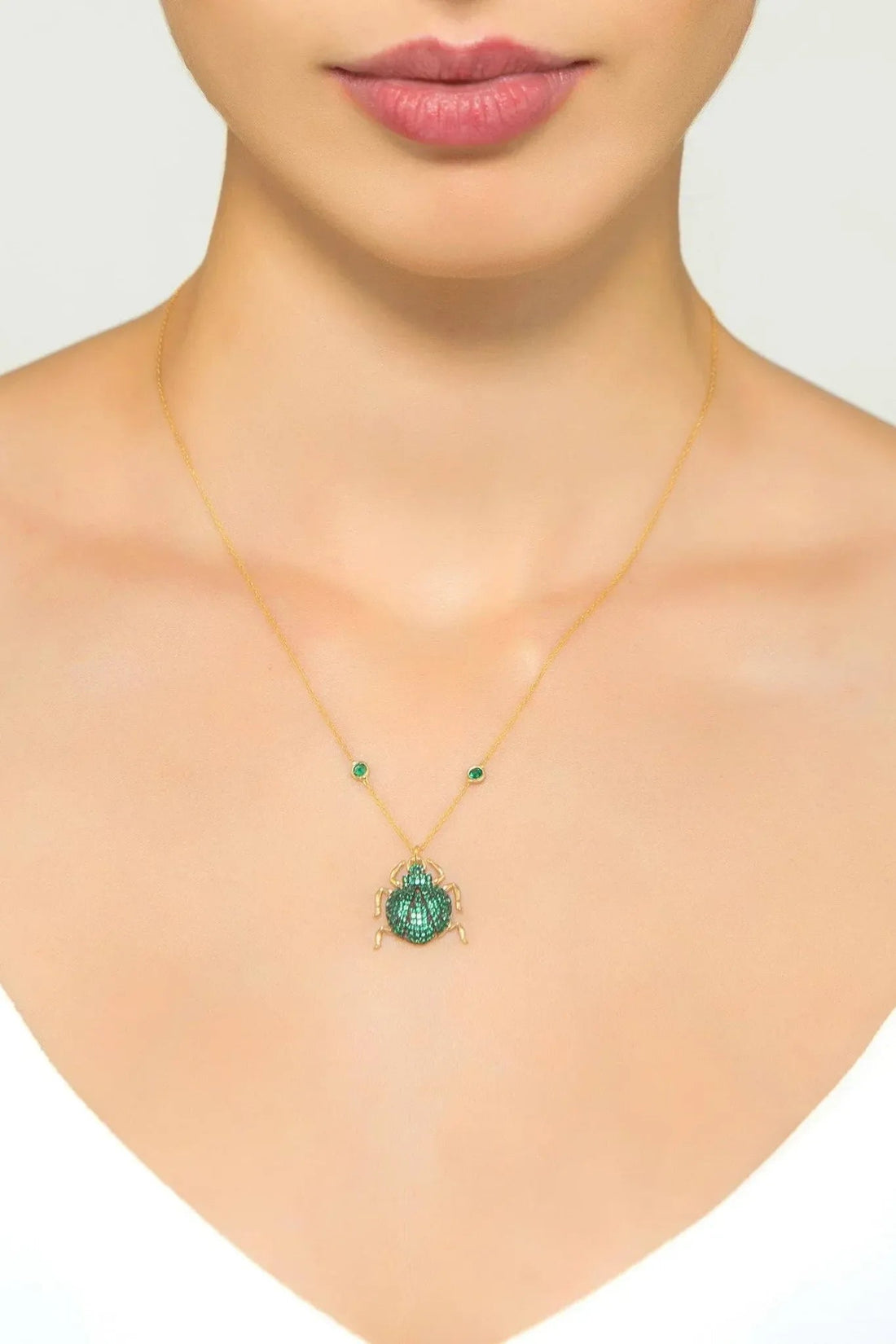 Gold-tone pendant necklace with small round green beads and green scarab charm