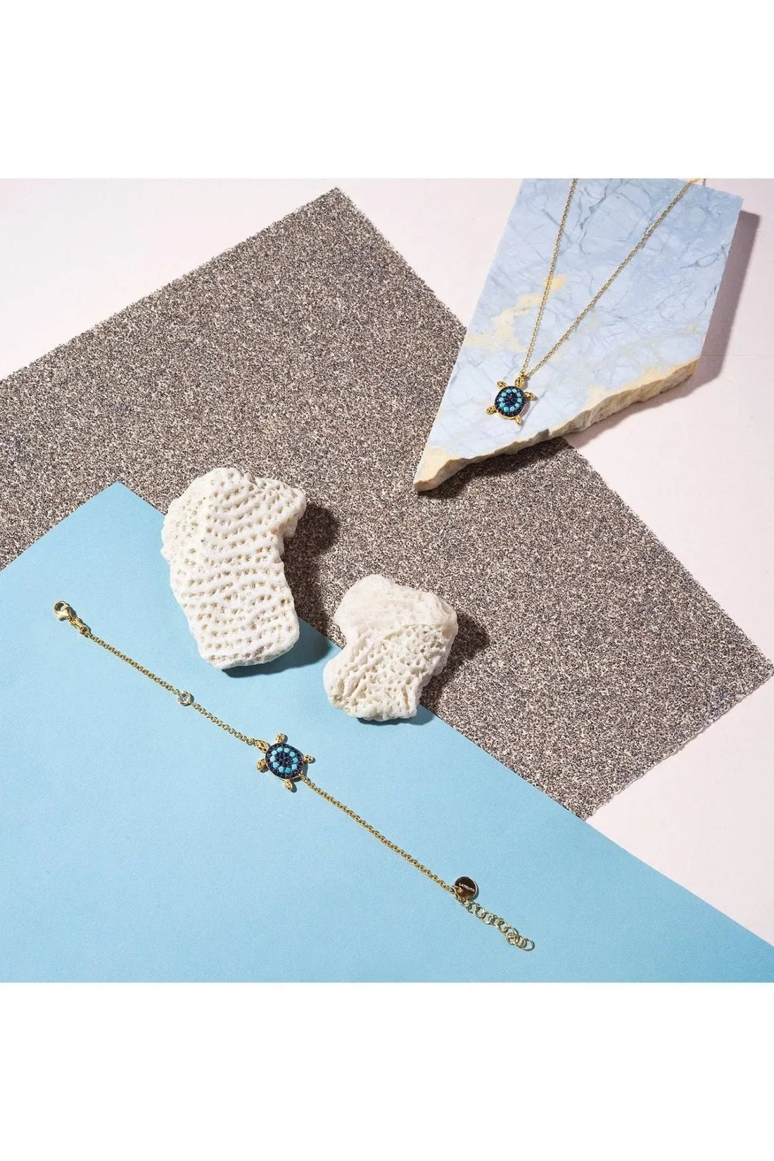 Gold-tone pendant necklace with blue turtle charm and turquoise stone accents