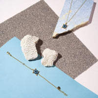 Gold-tone pendant necklace with blue turtle charm and turquoise stone accents