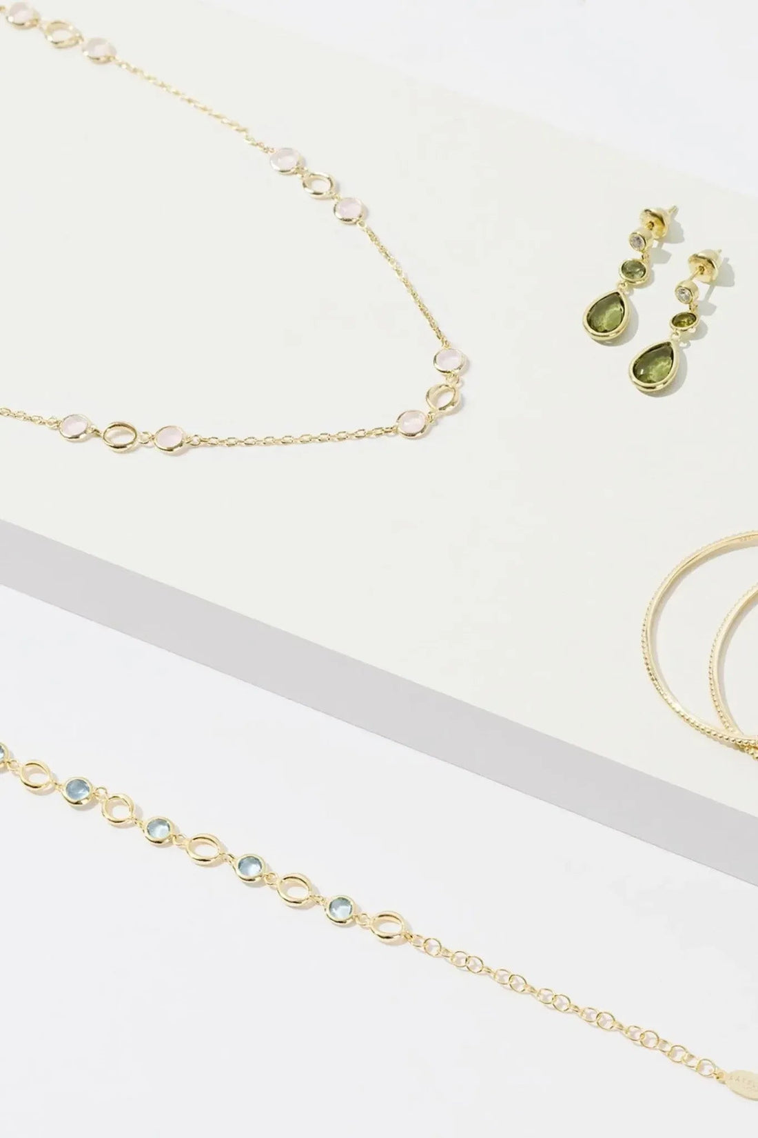 Gold-tone jewelry set with chain necklace and small green gemstone earrings