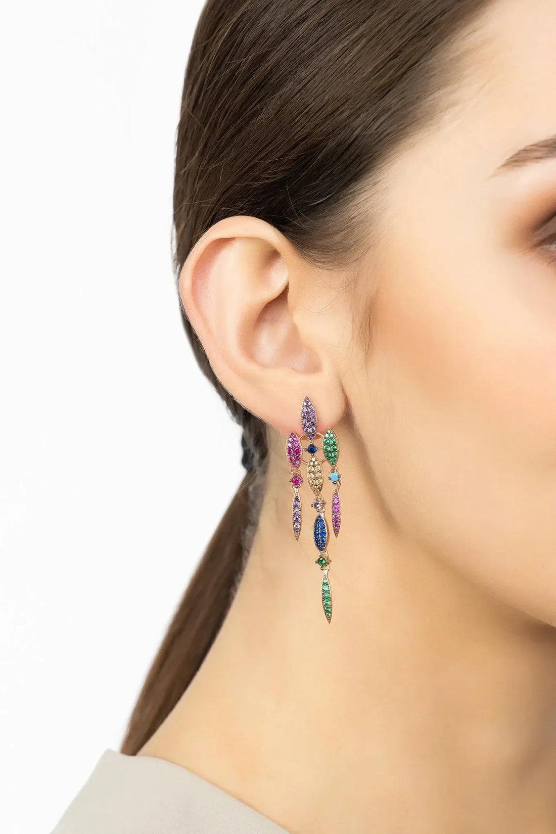 Rainbow crystal drop earrings in rose gold, shown on ear