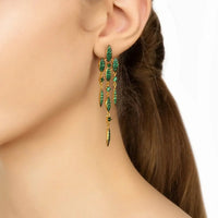 Emerald green CZ drop earrings on ear with gold-tone hooks