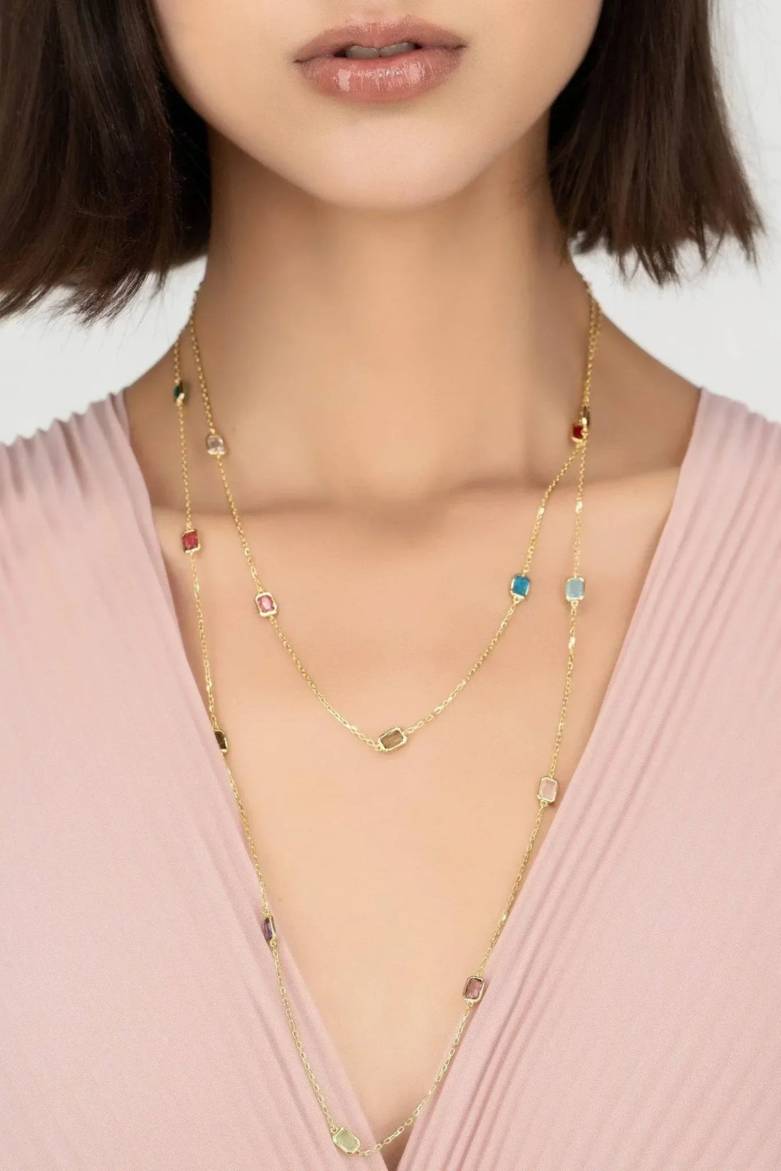 Gold layered rainbow bead necklace with small colored charms and clasp