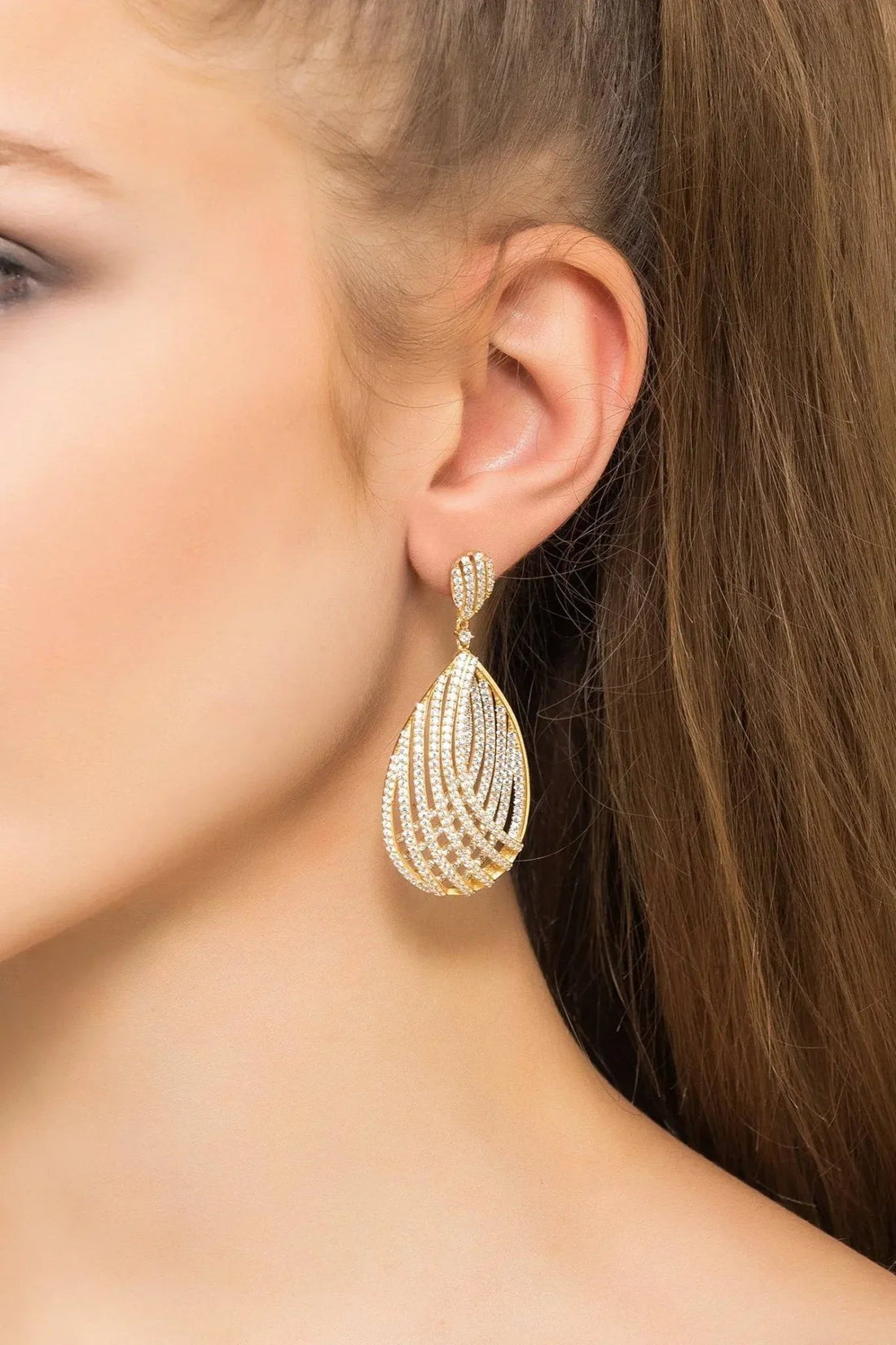 Gold teardrop earring with pavé crystal swirl design