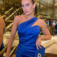 Blue and gold drop earrings on model’s ear, three-stone faceted design
