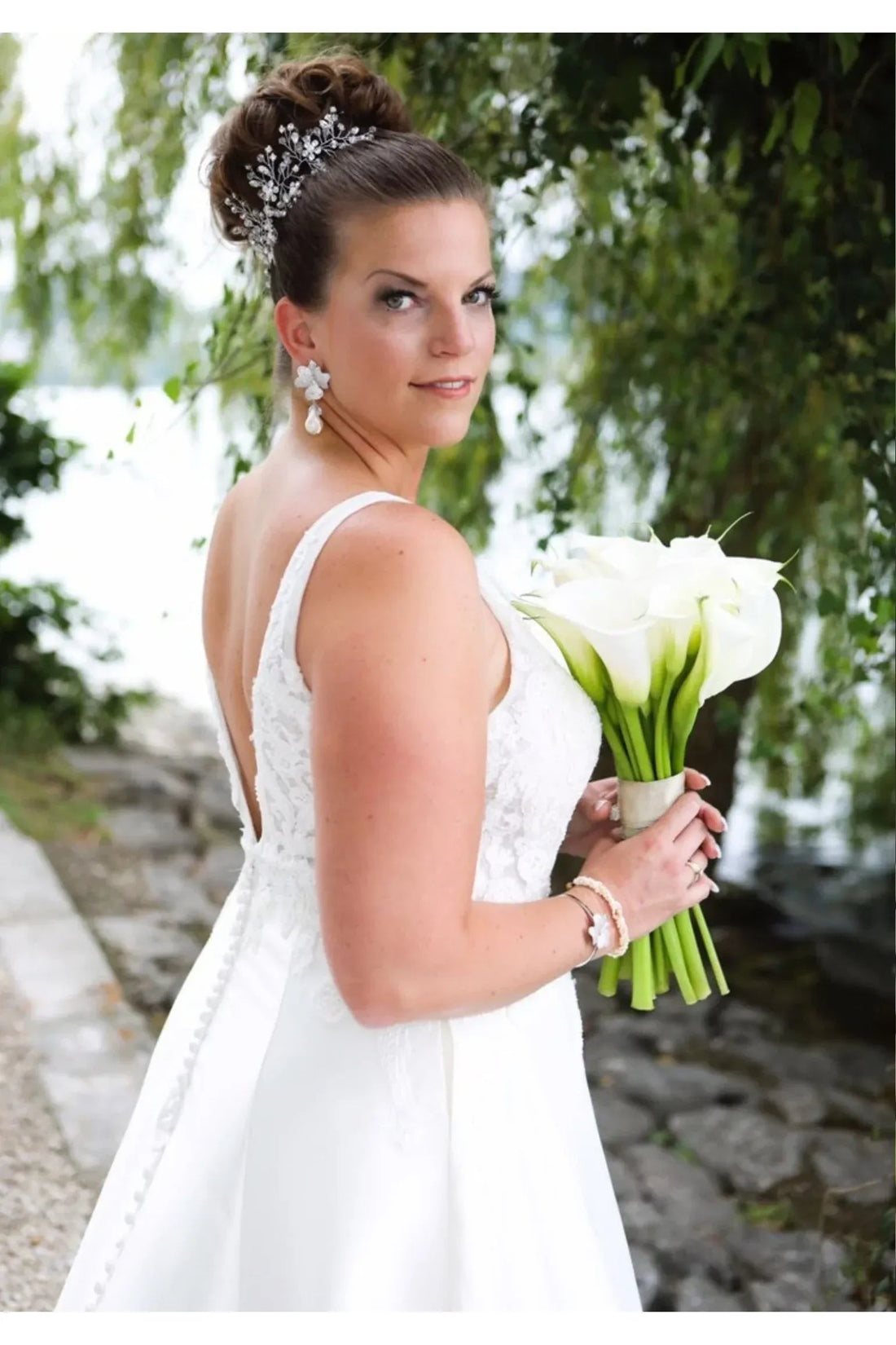 Bride wearing silver textured flower drop earrings with white pearl dangles