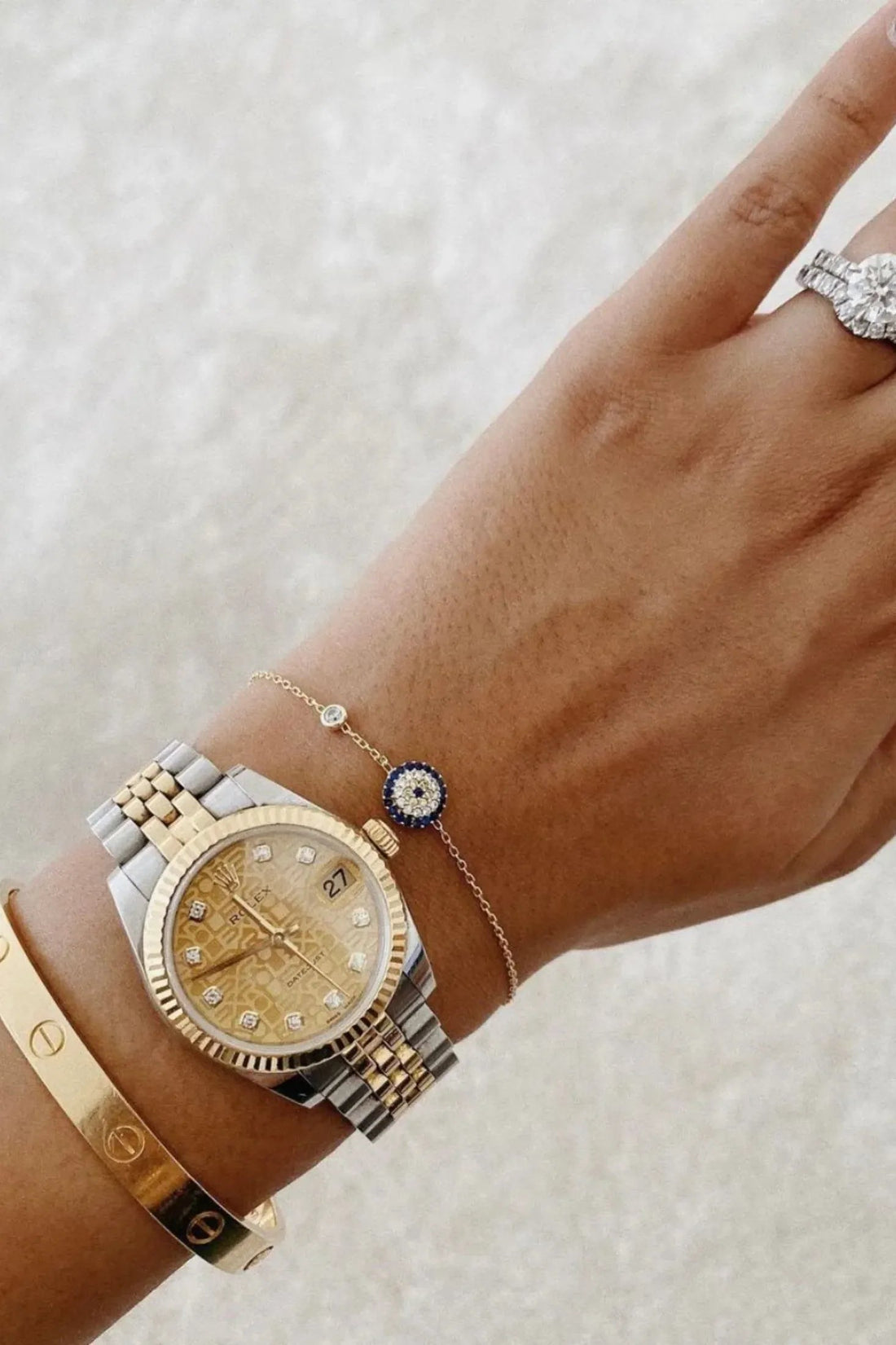 Gold evil eye bracelet on wrist with round blue eye charm