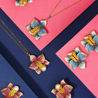Set of blue crystal daffodil earrings with gold-tone centers and pearl drops