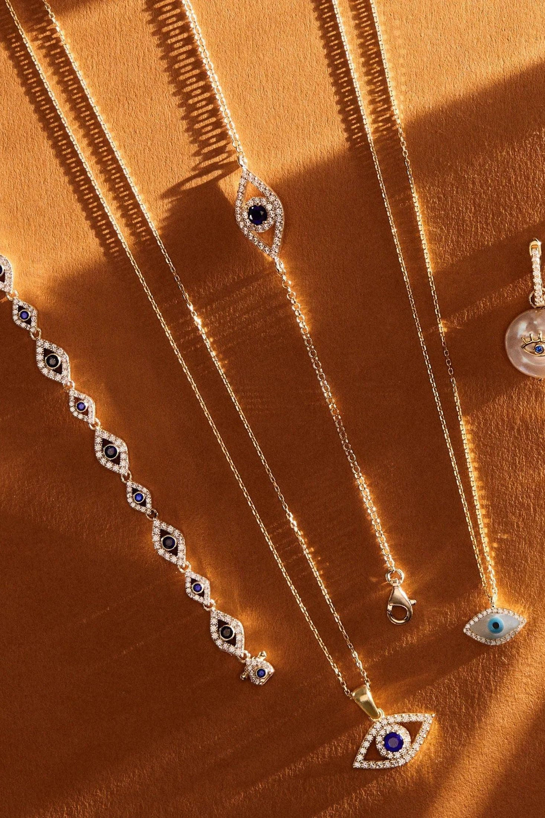 Gold-tone evil eye necklaces with blue eye pendants and crystal accents