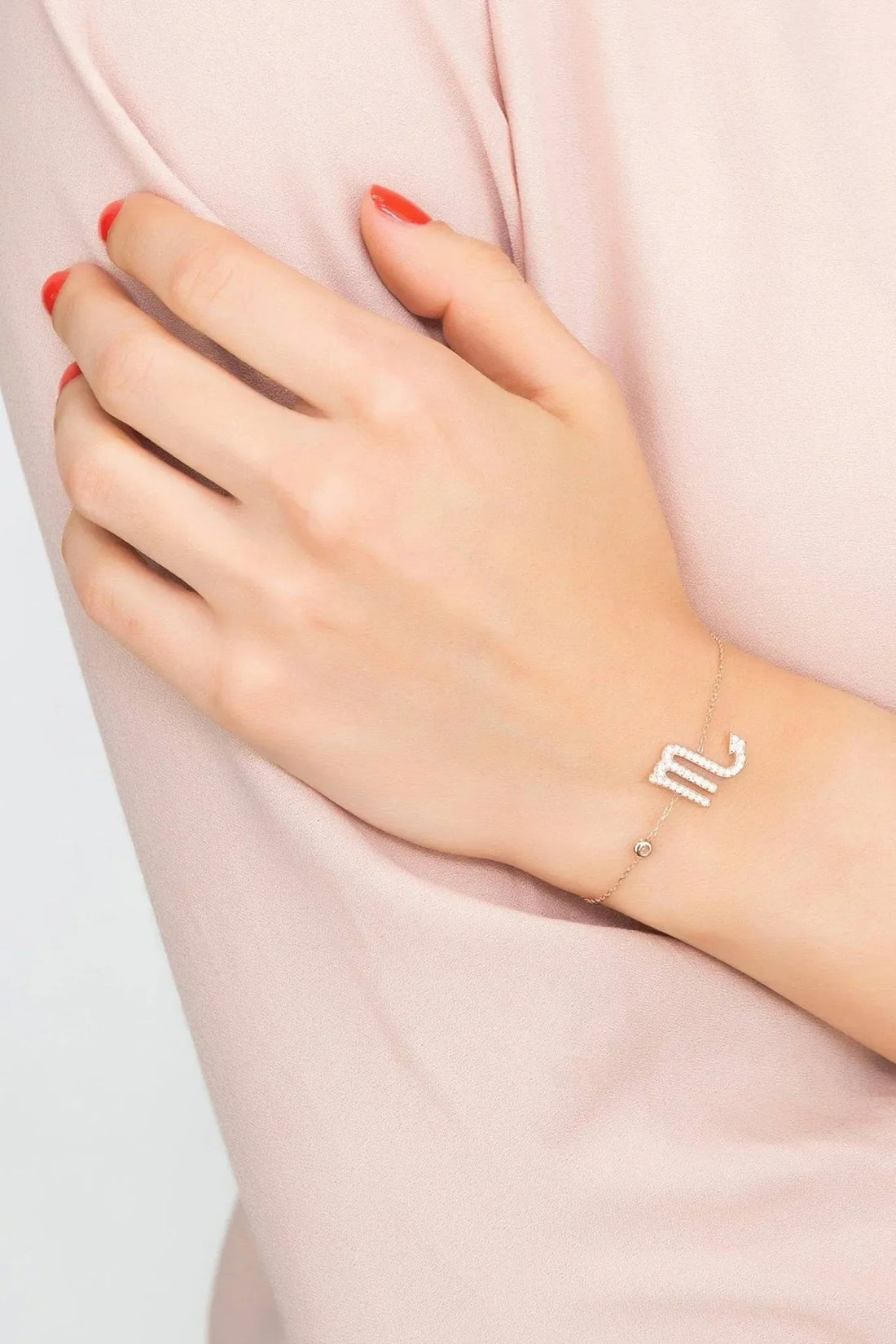 Rose-gold tone Scorpio bracelet with small scorpion zodiac charm on wrist
