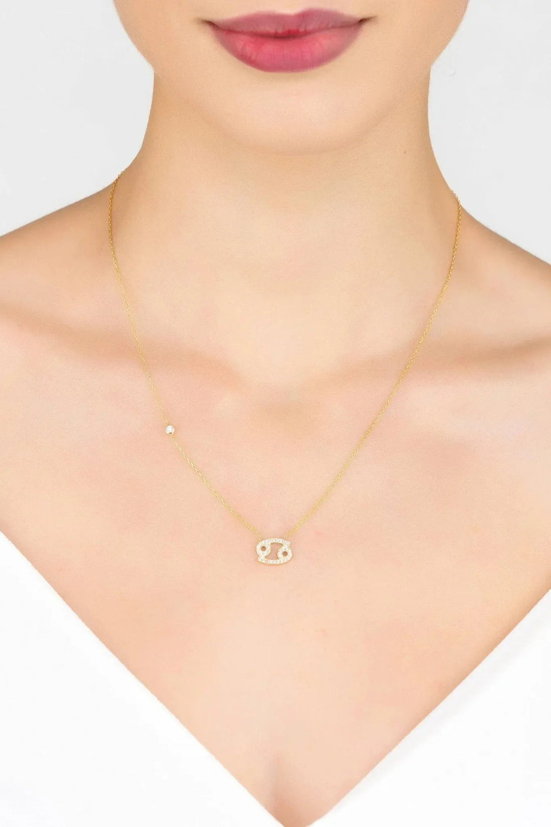Gold Cancer pendant necklace worn at collarbone with thin linked chain